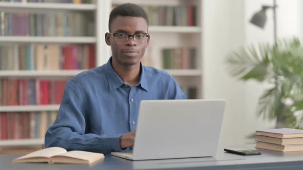 Young African Man Showing Thumbs Up While Using Laptop