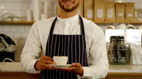 Smiling waiter serving cup of coffee 4k