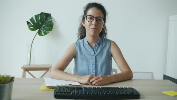 Portrait of Young Female Office Worker Talking and Gesturing Looking at Camera During Online Video