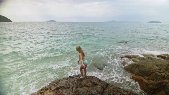 Woman Chill Relax Resting on Rock of Sea Reef Stone Stormy Cloudy Ocean