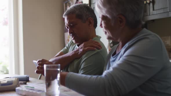 Senior mixed race couple having online medical consultation using smartphone