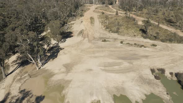 Drone aerial footage of telephone lines along a dirt road in regional Australia