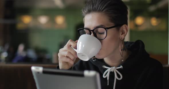 Thinking Girl Drinking Coffee and Using Tablet