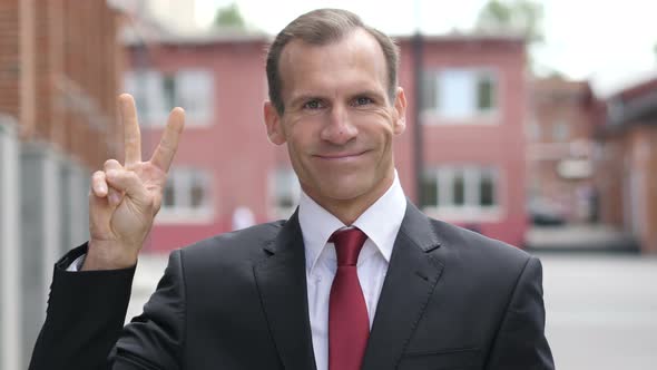 Victory Sign by Positive Businessman