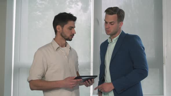 Young Employee Reports His Head at the Office Near the Window.