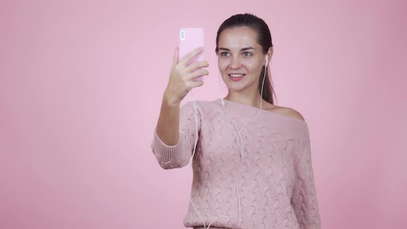 Girl Blogger Makes Video Story Using Mobile Phone Isolated on Pink Background