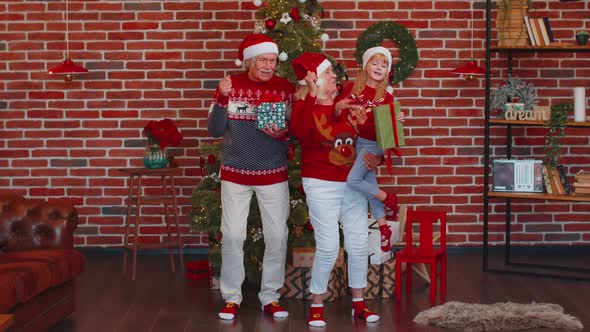 Cheerful Old Grandparents with Granddaughter Child Kid Dancing at Home Near Decorated Christmas Tree