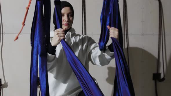 A Young Woman in Hijab Uses the Yoga Hammock in the Studio