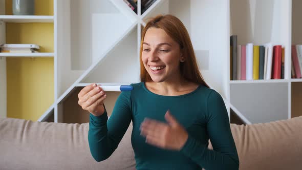 Happy Woman Takes a Pregnancy Test and She Reads That She Is Pregnant