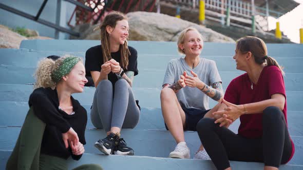 Group of Four Young Women, Best Friends Sitting Outdoor and Talking.