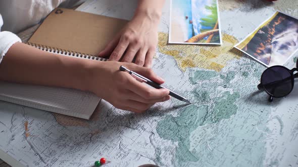 A Table With A Map On It. A Woman Makes A Travel Itinerary. Traveler With Travel Items Sunglasses