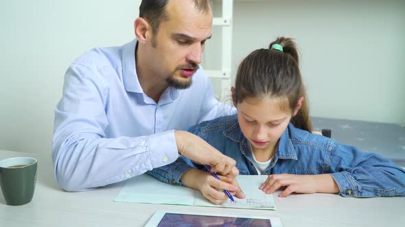 Father Helping his Daughter to do Homework