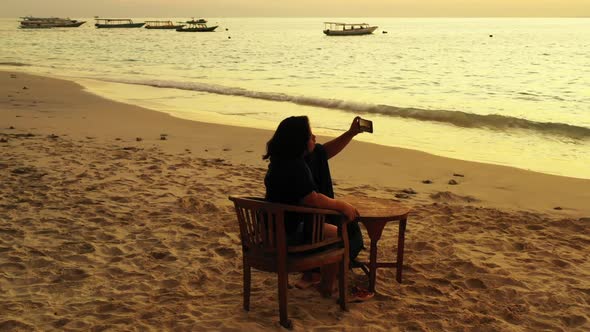 Single female sunbathing on beautiful bay beach time by blue green ocean with white sand background 