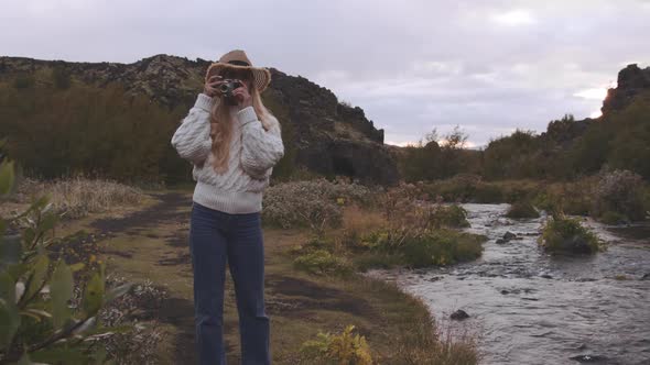 Woman On Riverbank Using Vintage Camera