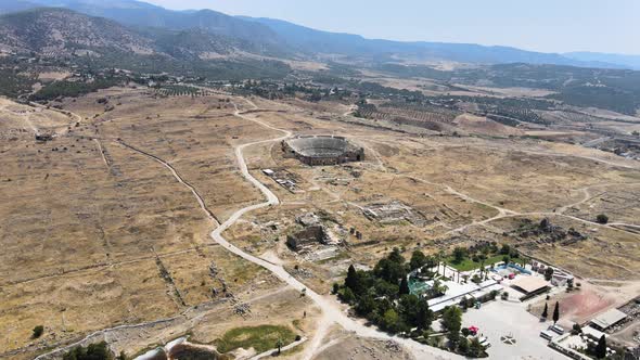 Drone flight over a hotel with a swimming pool over the ruins of an ancient fortress over a mountain