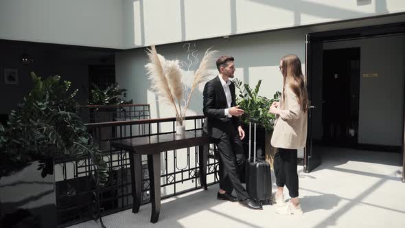 Successful Businessman with Baggage Arriving at Business Hotel Speaking Manager