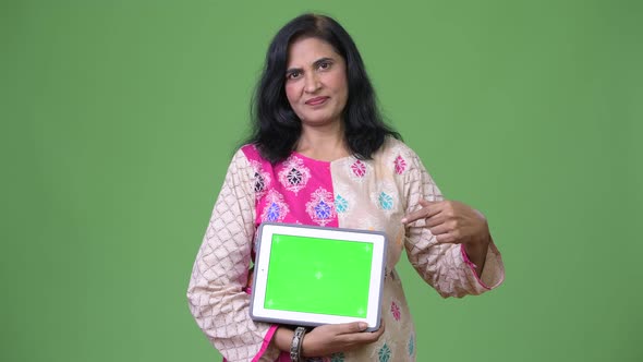 Mature Beautiful Indian Woman Showing Digital Tablet and Pointing Finger