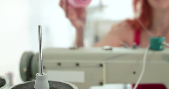 Close View of Female Tailor Fills the Sewing Machine with Pink Thread