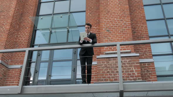 Young Businessman Using Tablet Outside Loft Office