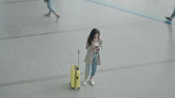 Young Woman Standing Near Suitcase Before Flight