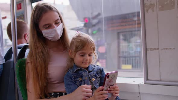 Tired Sleepy Woman with Daughter Going Home By Bus After Hard Work Day Child Kid Play on Smartphone