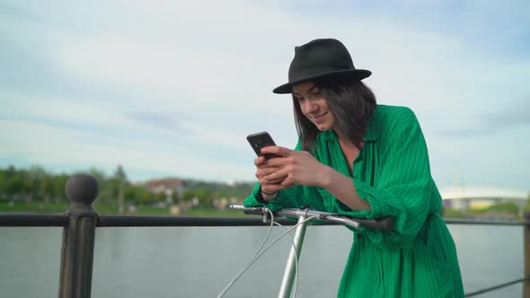 Girl leaning on the bike handle and texting