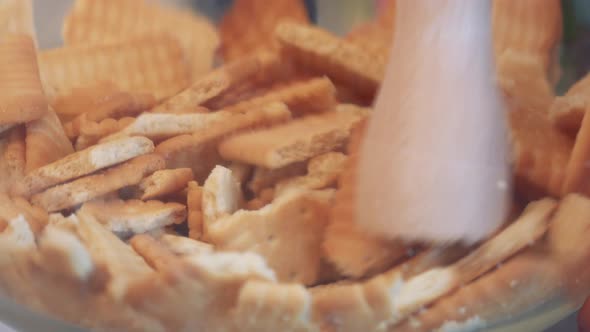 Cookies Are Crushed Into Crumbs in a Glass Bowl with a Pestle - Closeup