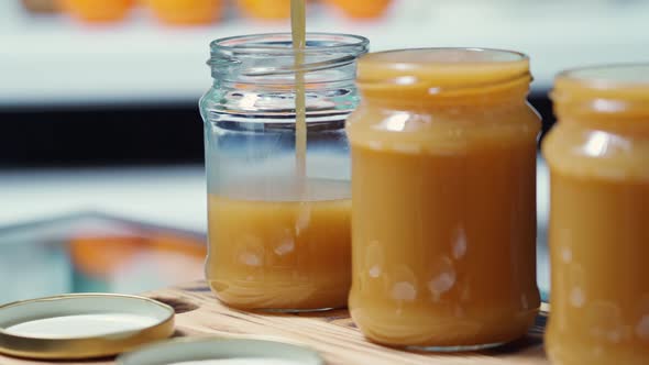 Hot Liquid Salted Caramel is Poured in a Thin Stream Into a Transparent Jar to the Very Edge