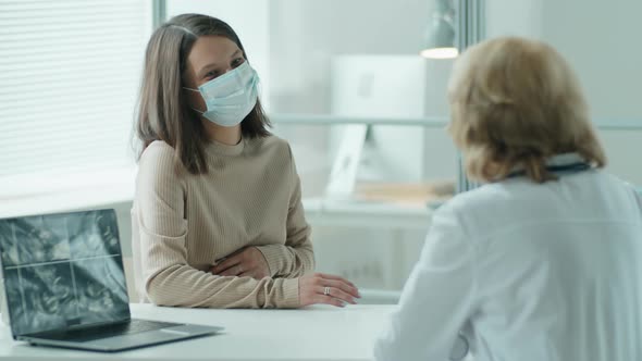 Pregnant Woman in Mask Visiting Doctor in Maternity Clinic