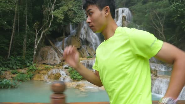 Asian Man Running, Waterfall at the Background