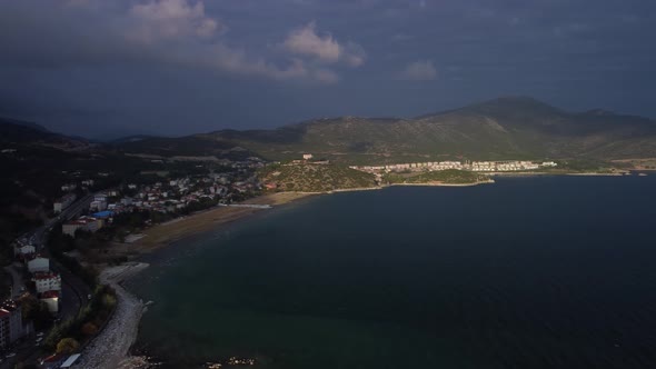 Long Coast with Town and Mountain Ridge are Filmed By Drone at Warm Summer Day