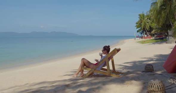 Young Female, She Enjoyes Her Coffee on Empty Sandy Beach in the Morning