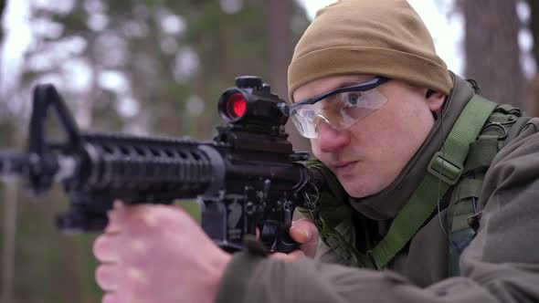 Portrait of Concentrated Man with Gun Aiming Walking in Forest Outdoors