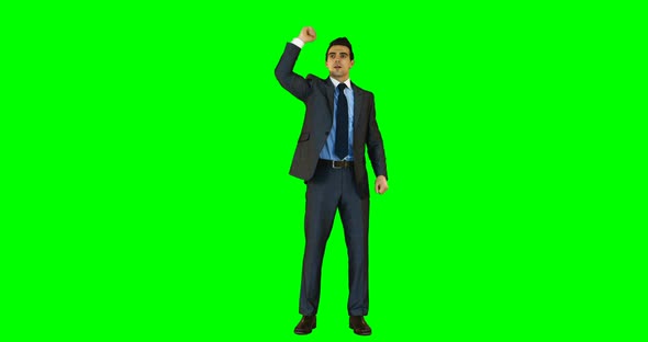 Businessman gesturing against green background