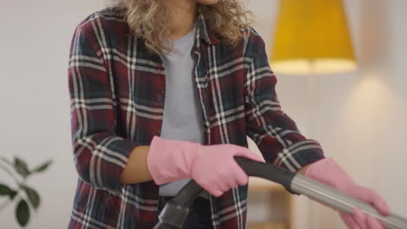 Woman in Gloves Vacuuming Couch Upholstery