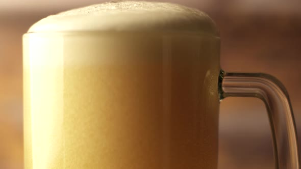 Closeup Shot of Beer is Poured Into a Beer Glass with a Handle a Lot of Bubbles and Foam That Flows