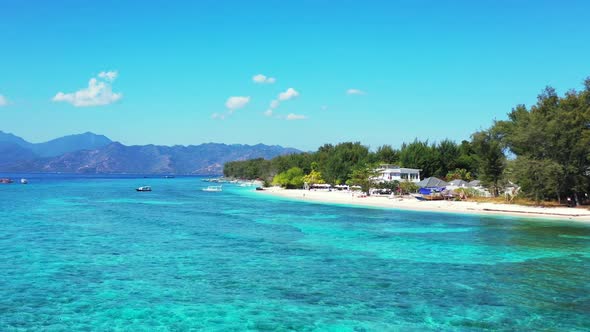 Aerial flying over seascape of idyllic sea view beach adventure by blue water and white sandy backgr