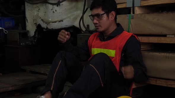 Desperate, hopeless and tired Asian male worker in jumpsuit, lean back to rest