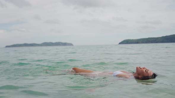 Woman In Bikini Lying On Back In Sea