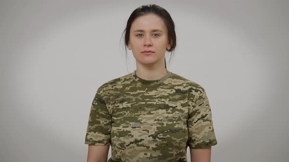 Portrait of Stressed Frustrated Female Soldier Trying Not to Cry Posing at Grey Background