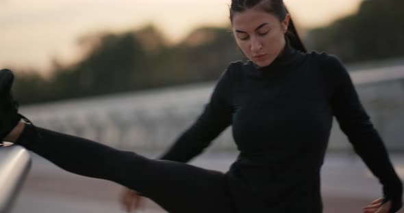 Sportswoman Warming Up Near Railing on Embankment