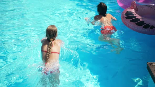 Girl Entering Blue Pool Swimming Away with Friend in Slow Motion Leaving