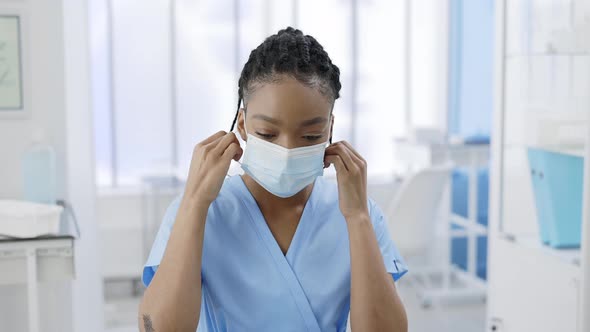 Crop View of Afroamerican Woman Taking Off Medical Protective Mask and Looking to Camera