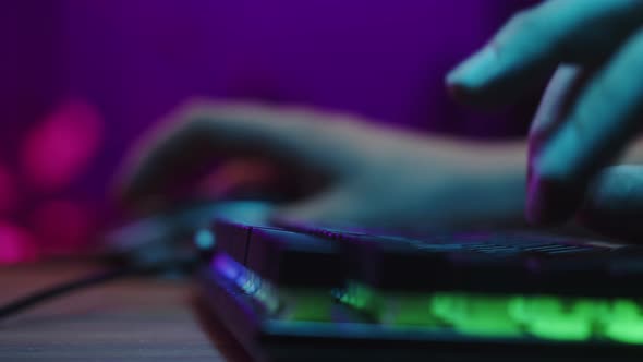 Gamer Typing on Backlight Keyboard Closeup Man Playing Video Game