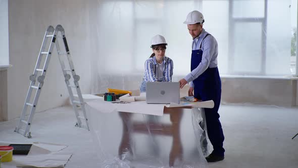 Man and Woman Choose Room Design on Computer and Use Color Palette to Choose Paint for Painting