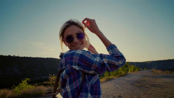 Cute girl flirting with the camera moves dancing enjoying the sunshine.