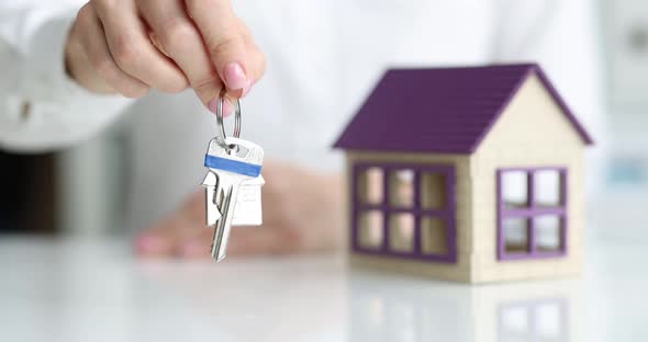 Agent Holds Key to House in Hand Closeup