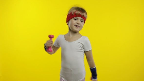 Caucasian Girl in Sportswear Making Exercises with Dumbbells. Workout for Kids. Athletic Child