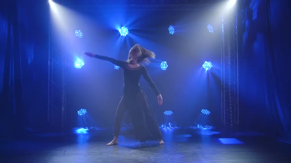 The Lovely Actress Dances Tender Sensual Contempt Against a Black Backdrop with Blue Backlighting. A