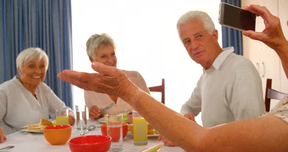 Woman photographing her senior friends